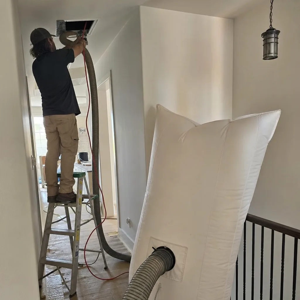 Technician using professional air duct cleaning equipment in a residential home