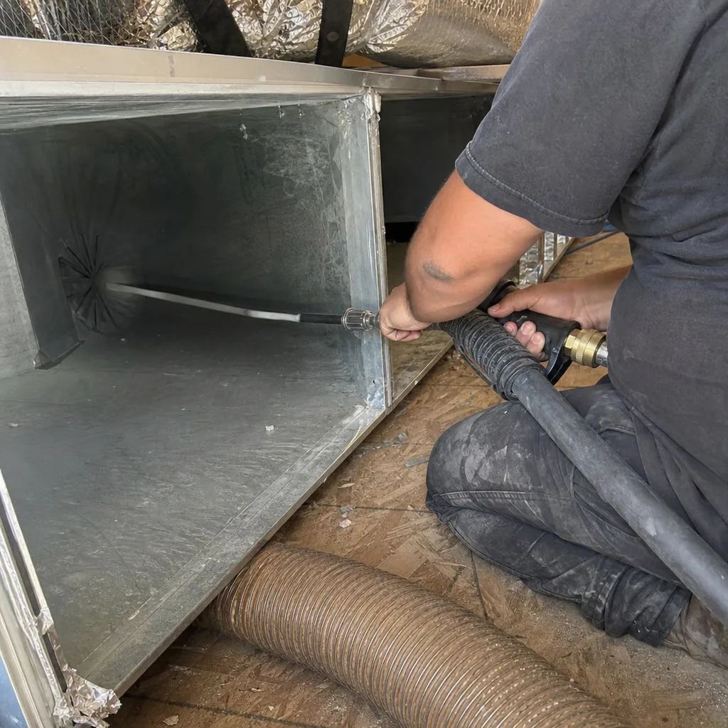 Technician performing professional HVAC air duct cleaning service